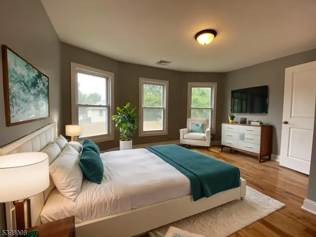 a bedroom with a large bed and a flat tv screen