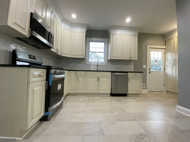 a kitchen with stainless steel appliances granite countertop a refrigerator and a stove top oven