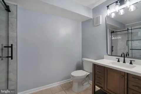 a bathroom with a toilet a sink and mirror