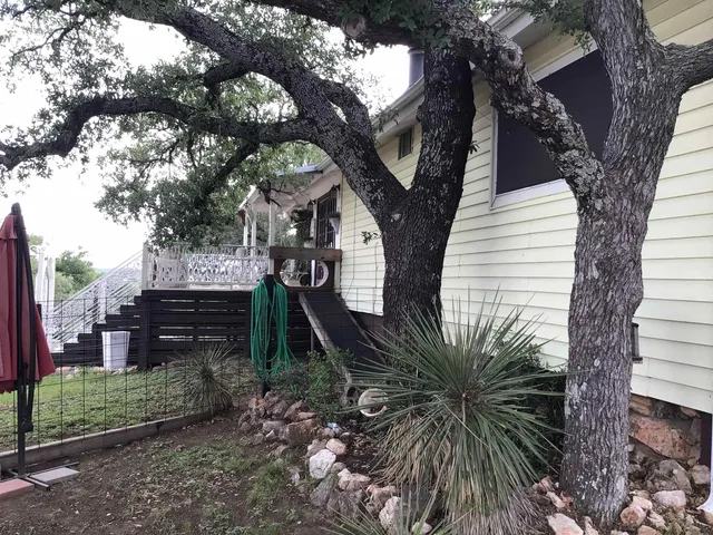 a view of a house with a tree in the yard