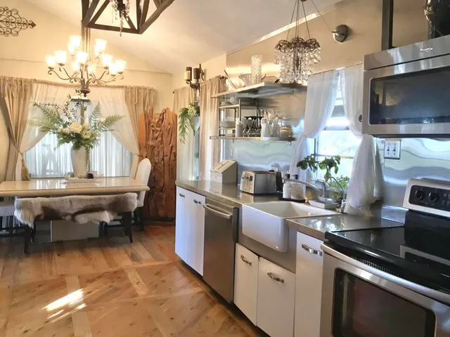 a kitchen filled with stainless steel appliances kitchen island granite countertop a sink and cabinets