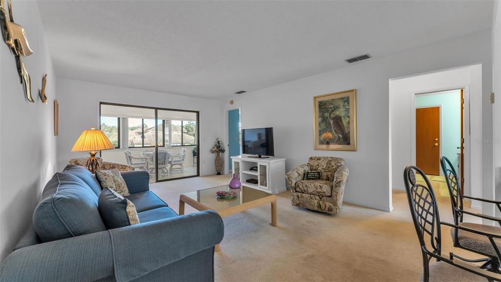 6051 Topher Trail, Unit 6051 Mulberry, FL 33860 - Photo 12 of 38 a living room with furniture and a flat screen tv