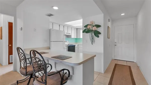 a white kitchen with a sink a stove and a refrigerator