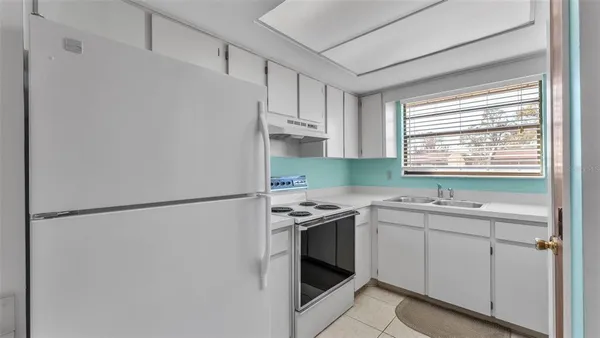 a kitchen with a sink a refrigerator and window