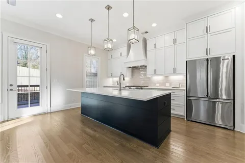 a kitchen with kitchen island a sink stainless steel appliances and wooden floor