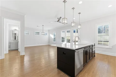 a kitchen with stainless steel appliances granite countertop a sink a stove and a wooden floor