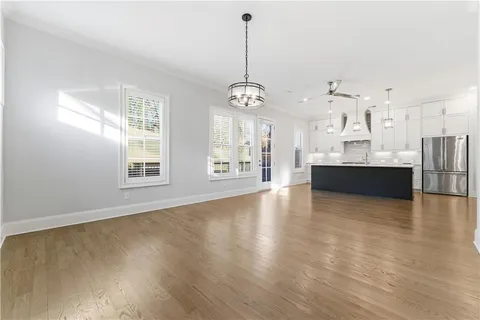 a view of a big room with wooden floor and windows