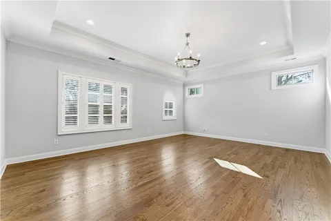 a large white room with a white toilet a sink and a mirror