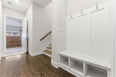 an empty room with wooden floor and ceiling fan
