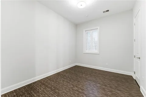 an empty room with ceiling fan and window