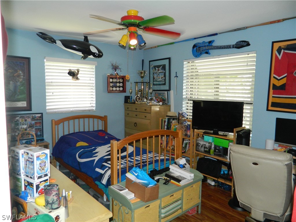 17396 Oriole Road Fort Myers, FL 33967 - Photo 10 of 17 a bedroom with furniture a fireplace and a flat screen tv