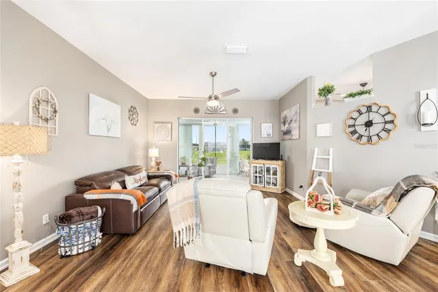 a kitchen with stainless steel appliances kitchen island granite countertop a refrigerator a stove a sink a dining table and chairs with wooden floor