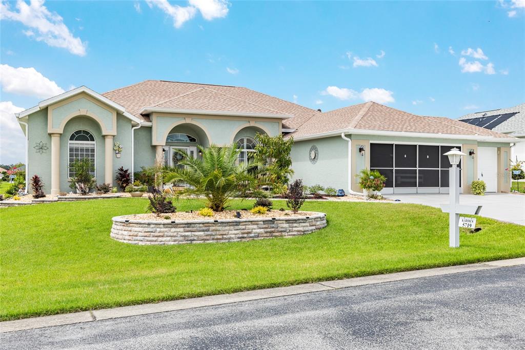 5719 Northwest 25th Loop Ocala, FL 34482 - Photo 2 of 67 a front view of a house with a garden