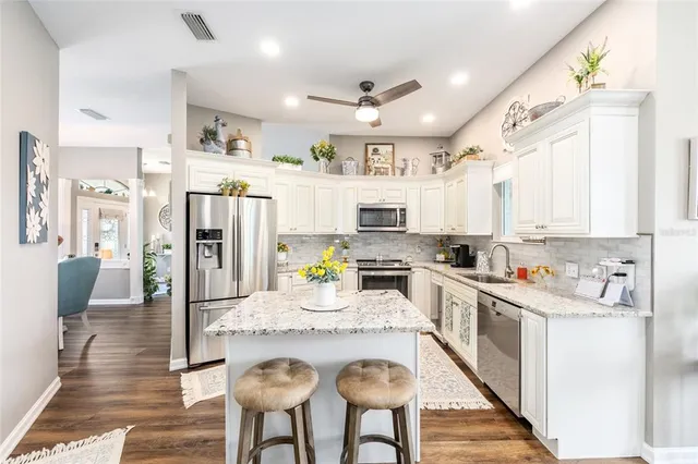 a bedroom with a bed a chandelier and dresser