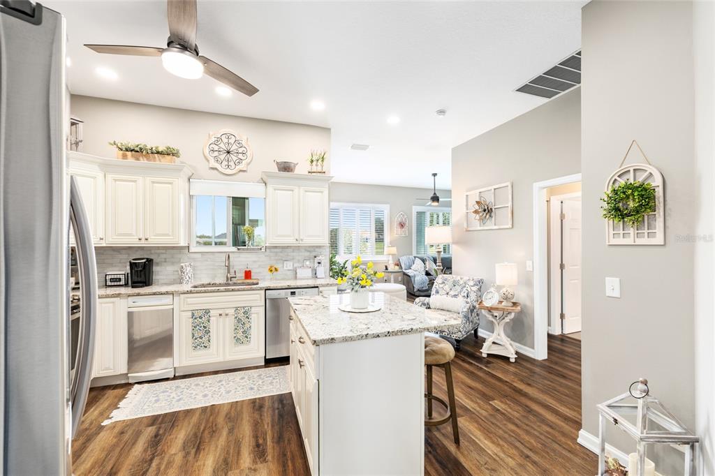 5719 Northwest 25th Loop Ocala, FL 34482 - Photo 26 of 67 a kitchen with stainless steel appliances granite countertop a refrigerator a sink dishwasher a stove and white cabinets with wooden floor