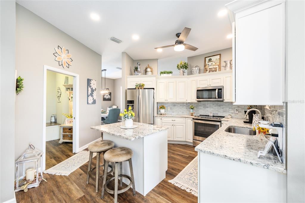 5719 Northwest 25th Loop Ocala, FL 34482 - Photo 28 of 67 a kitchen that has a lot of white cabinets and stainless steel appliances
