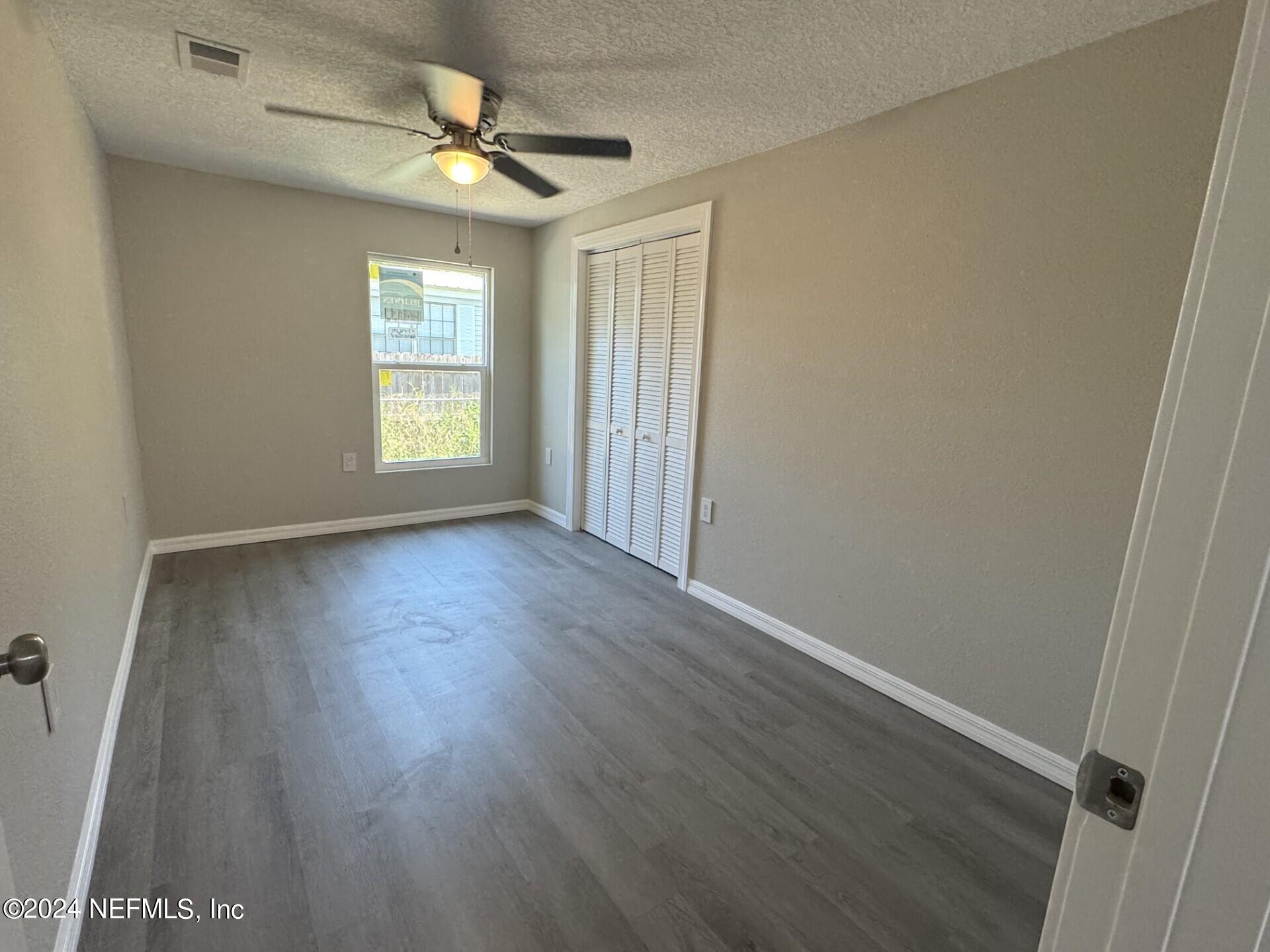 130 Boca Raton Road Satsuma, FL 32189 - Photo 12 of 20 an empty room with wooden floor and windows