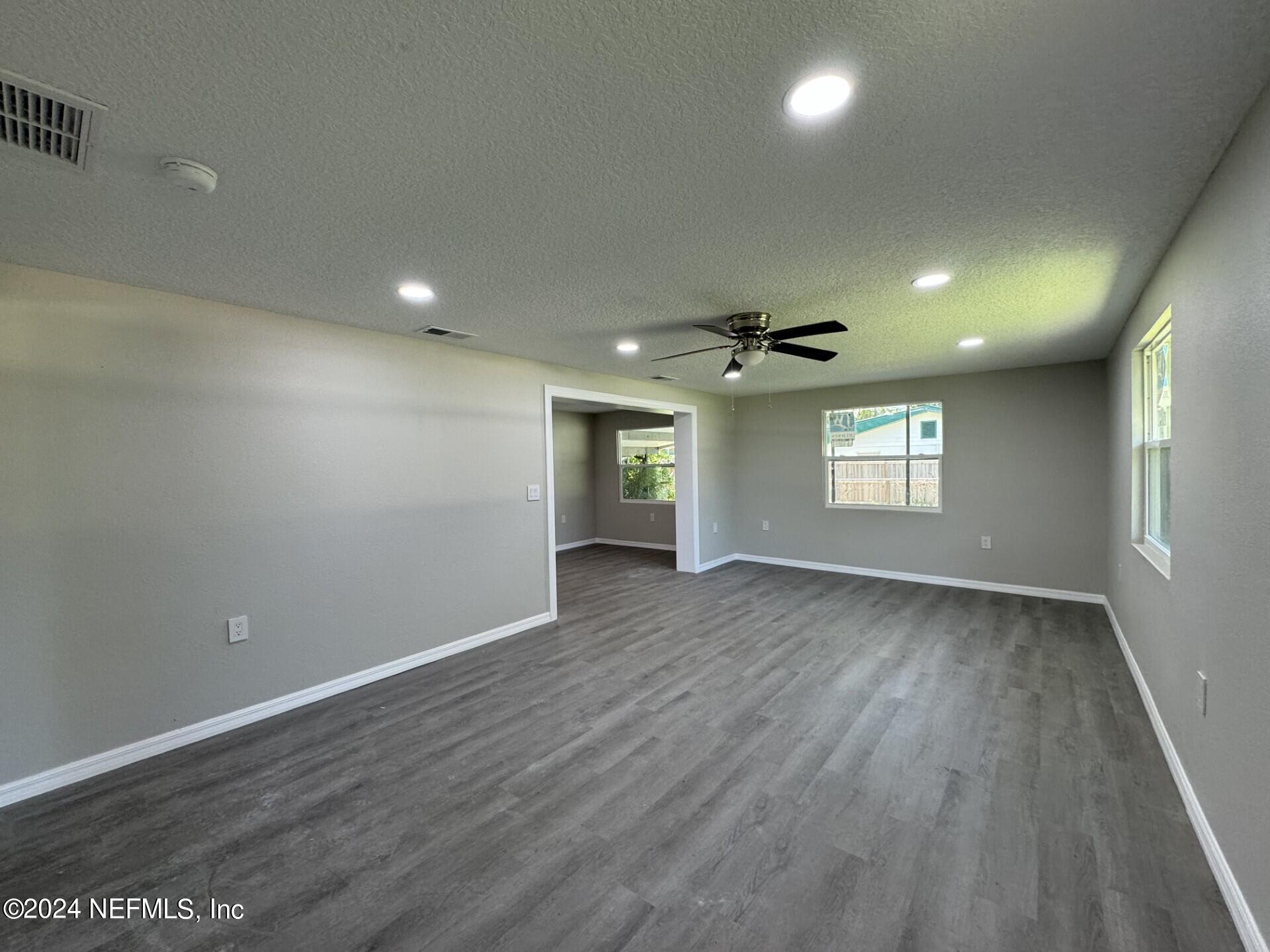 130 Boca Raton Road Satsuma, FL 32189 - Photo 4 of 20 an empty room with wooden floor and windows
