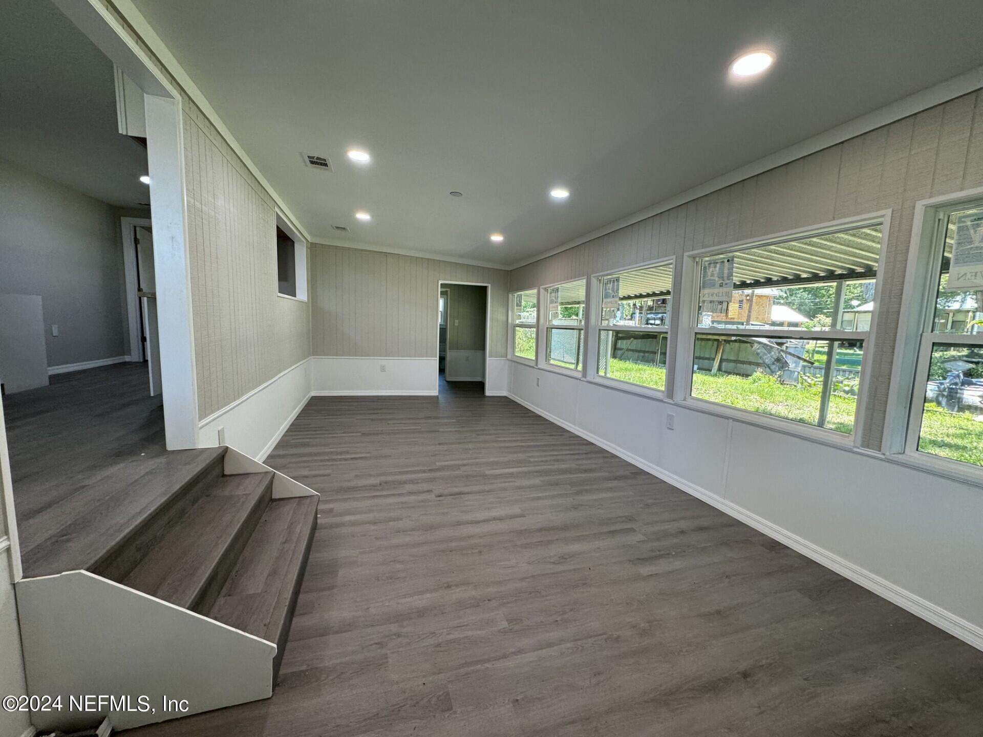 130 Boca Raton Road Satsuma, FL 32189 - Photo 6 of 20 an empty room with wooden floor and windows