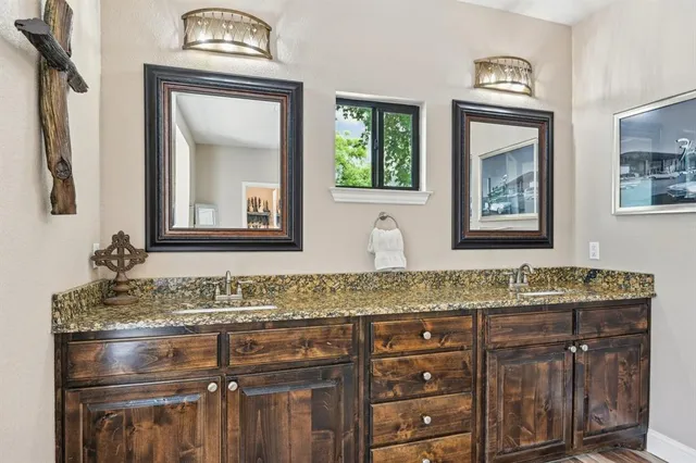 a en suite bathroom with a granite countertop sink and a mirror