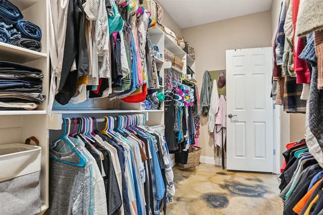 a view of walk in closet with clothes and shoes