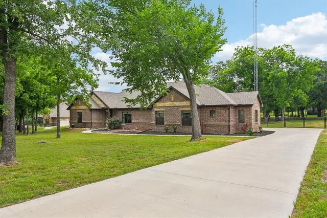 a front view of a house with a yard and trees