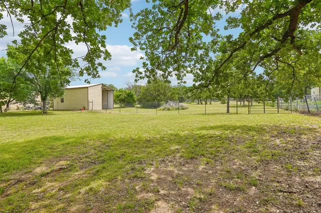 a view of a field with trees in the background