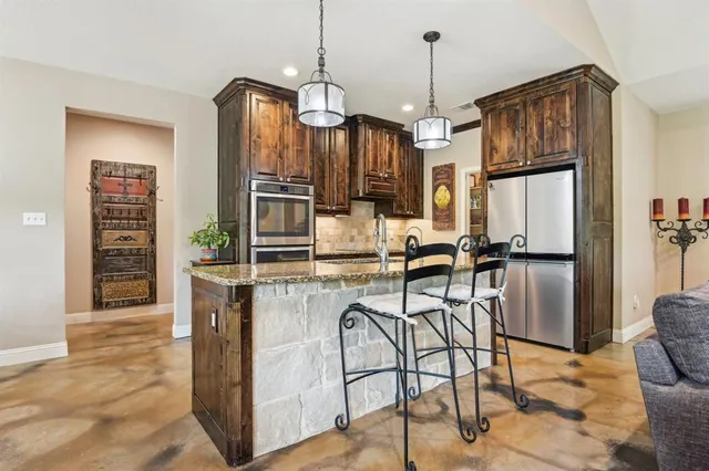 a kitchen with stainless steel appliances granite countertop a stove and a refrigerator