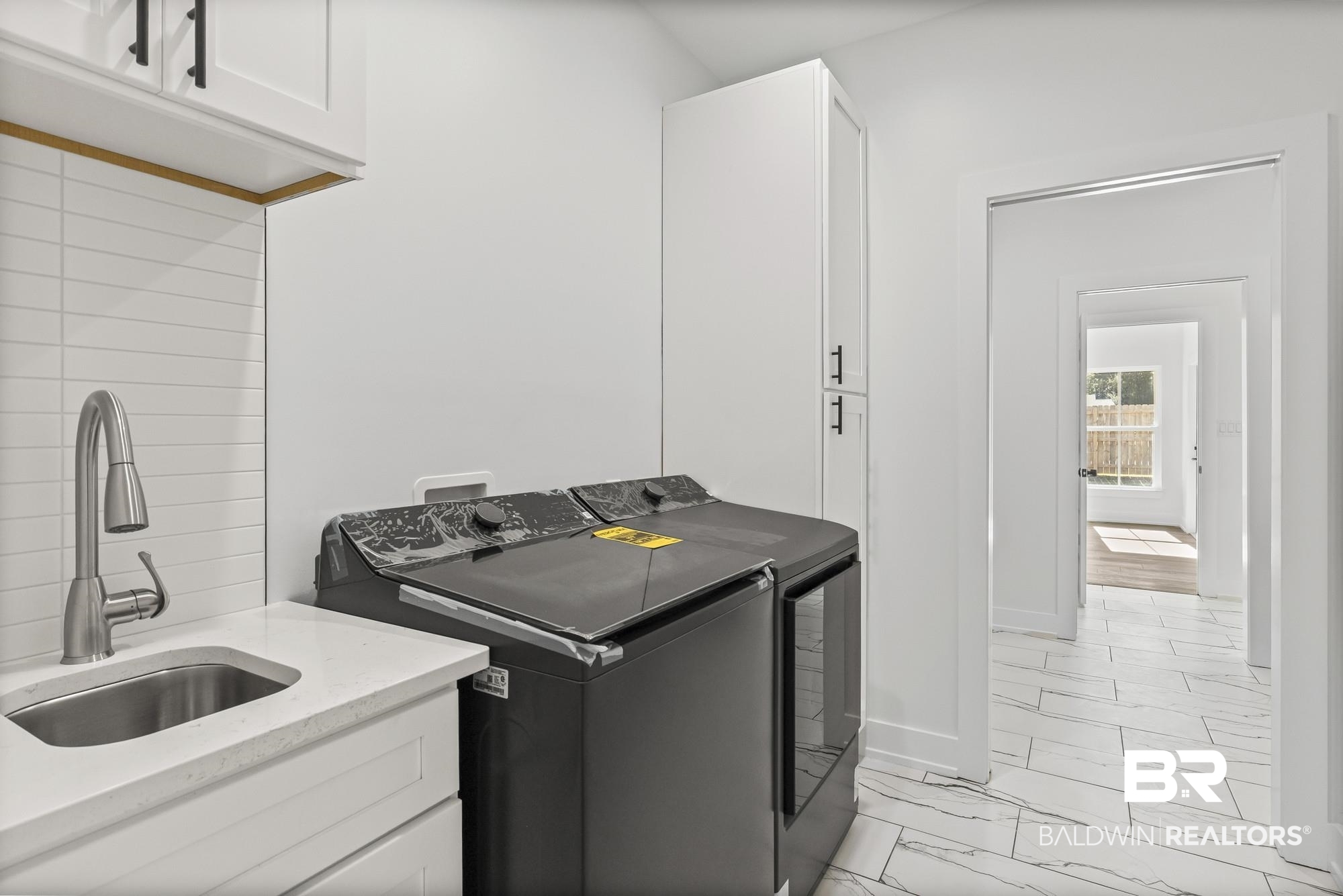 10180 Pineview Drive Foley, AL 36535 - Photo 25 of 47 Laundry area with light marble finish flooring, washer and clothes dryer, and cabinet space
