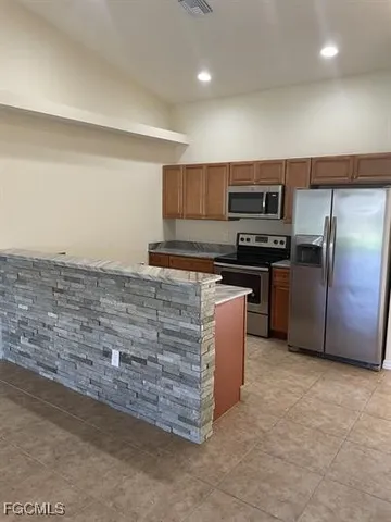 a kitchen with stainless steel appliances granite countertop a stove a sink and a refrigerator