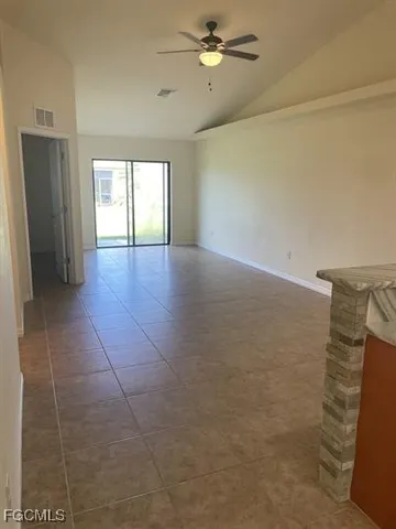 a view of empty room with windows and ceiling fan