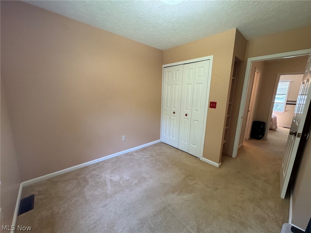 8201 Orchard Road Painesville, OH 44077 - Photo 33 of 45 Carpeted interior room with neutral-toned walls, white bi-fold closet doors, and white baseboards