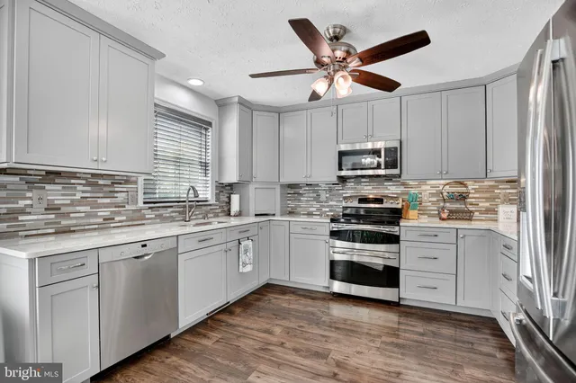 a kitchen with granite countertop white cabinets white stainless steel appliances and sink
