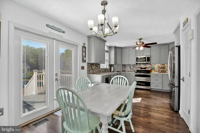 a view of a dining room and livingroom with furniture wooden floor a chandelier