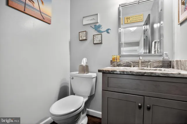 a bathroom with a granite countertop toilet sink and mirror