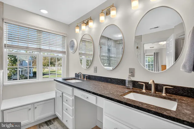 a bathroom with double vanity sinks and a large mirror