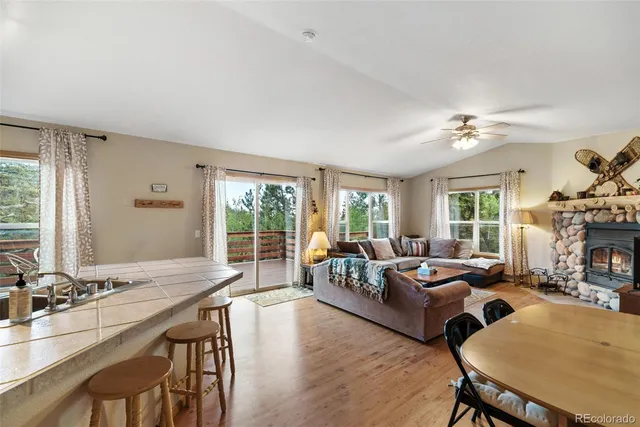 a living room with fireplace furniture and a large window
