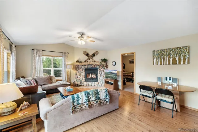 a living room with furniture a fireplace and a large window