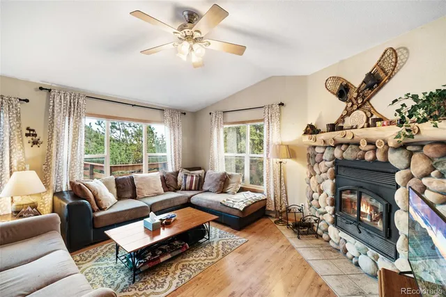a living room with furniture a fireplace and a floor to ceiling window