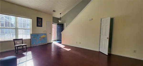 a bedroom with wooden floor and a window
