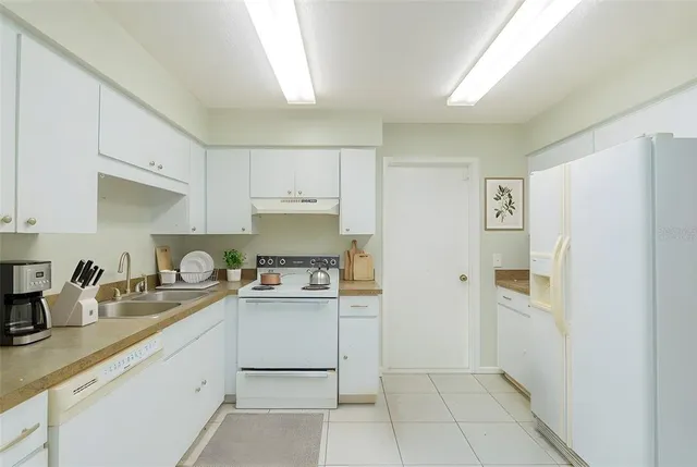 a kitchen with a sink a refrigerator and cabinets