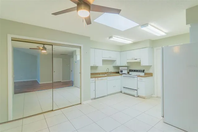 a kitchen with white cabinets and white appliances