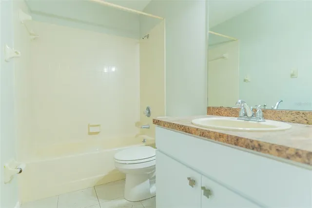 a bathroom with a granite countertop sink a toilet and shower