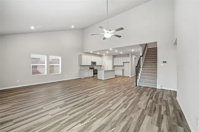 wooden floor in an empty room with a kitchen