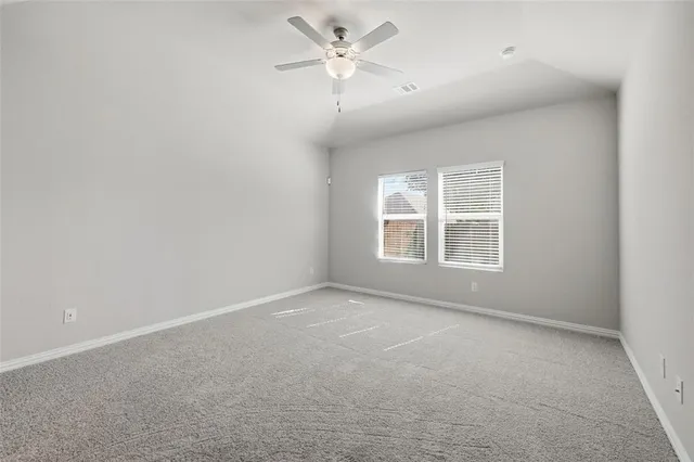 an empty room with windows and fan