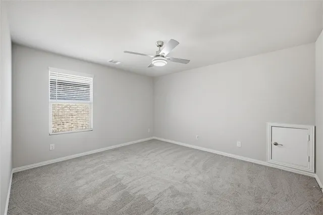 an empty room with a window and a ceiling fan