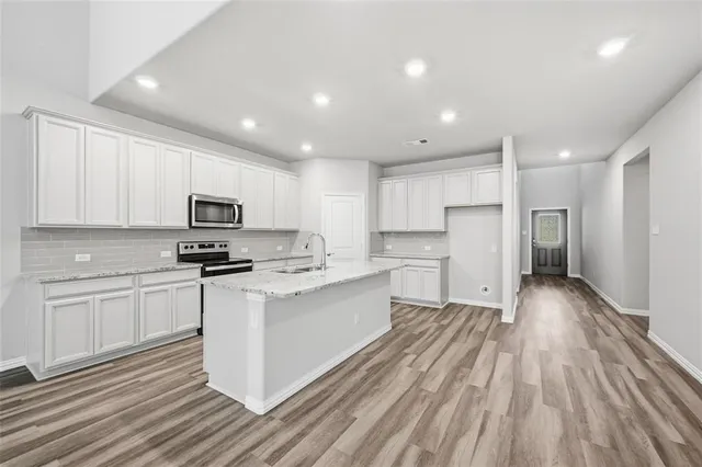 a kitchen with white cabinets and stainless steel appliances