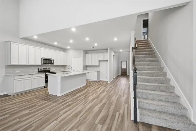 a kitchen with white cabinets and stainless steel appliances