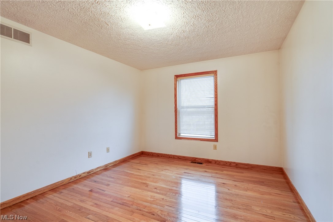 5303 Laubert Road Atwater, OH 44201 - Photo 23 of 37 Empty room with light wood-type flooring and a textured ceiling