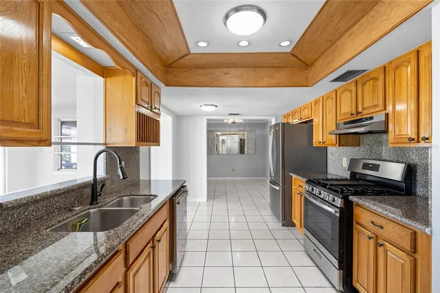 a kitchen with granite countertop a stove a sink and a microwave